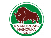 Logo KS Puszcza Hajnówka Logo w kształcie biało – zielonego koła. W centralnym miejscu narysowany brązowy żubr, pod nim na białym tle brązowy napis: K.S. <<Puszcza>> Hajnówka 1937r. 