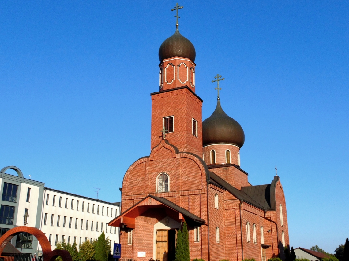 zdjęcie przedstawia budynek cerkwi zbudowanej z czerwonej cegły, posiada dwie kopuły