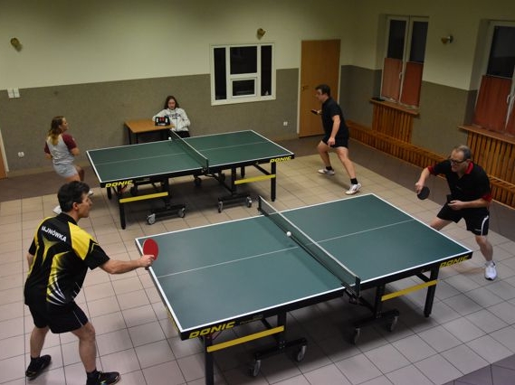 Przy dwóch stołach do tenisa czterech zawodników rozgrywana mecze