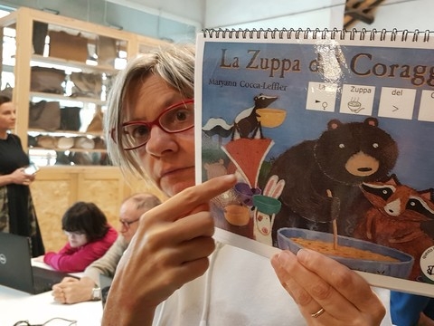 Kobieta pokazuje okładkę, na której narysowane są zwierzęta