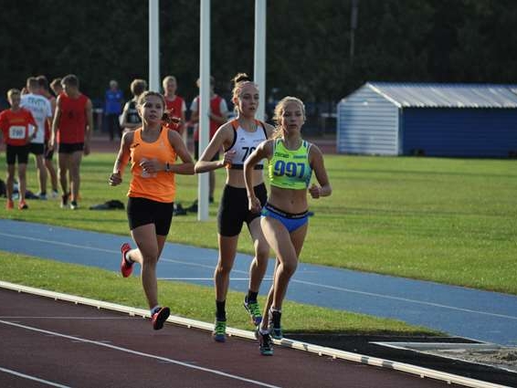 Trzy kobiety biegną w sportowych strojach.