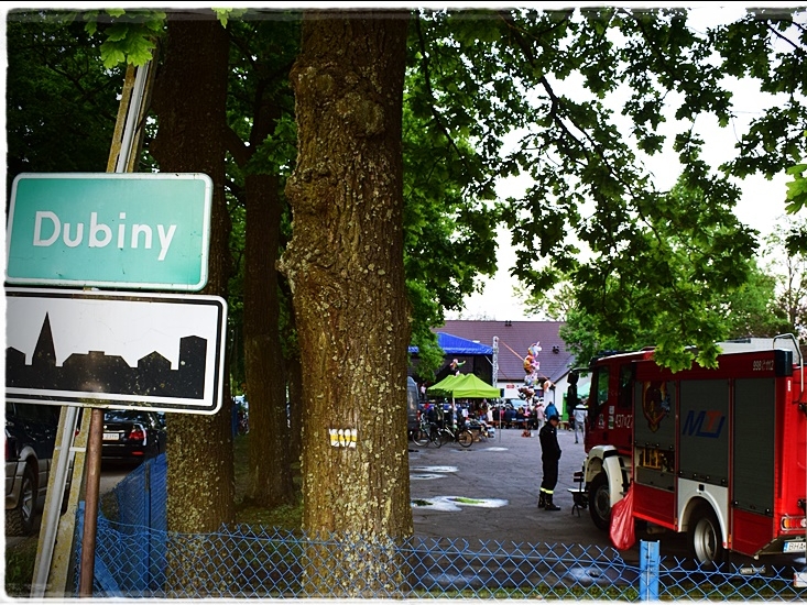 znak z nazwą wsi DUBINY i widok na festyn