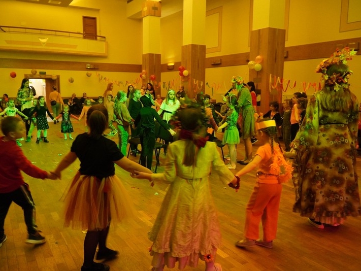 dzieci przebrane tańczą w sali kolumnowej domu kultury