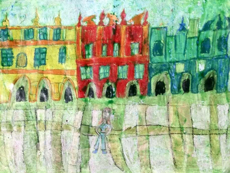 trzy budynki w kolorach żółty, czerwony i zielony - kamieniczki w Zamościu. Przed nimi stroi dziewczynka