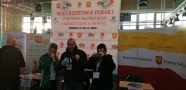 Na zdjęciu trzech mężczyzn unosi pięści, za nimi plakat z napisem: Mistrzostwa Polski Juniorek Młodzików i Młodziczek w boksie.