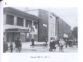  Stacja PKP w 1987 r. [tekst alternatywny: skan czarno-białego zdjęcia, na którym widoczni są podróżujący, stojący na peronie przed wejściem do budynku dworca]