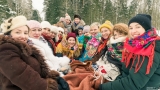 Zimowa sceneria. Grupa kobiet siedzie w kolorowych chustach.
