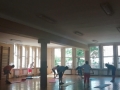 grupa osób ćwicząca przy matach w sali gimnastycznej 