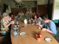 grupa osób siedzi przy stole w sali i spożywa posiłek