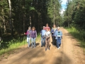 Grupa ludzi idących przez las.