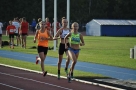 Trzy kobiety biegną w sportowych strojach.