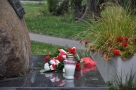 kwiaty oraz znicze ułozone przy pomniku 