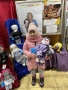 Dziecko,  którego rodzice zdecydowali się kupić lalki na kiermaszu.