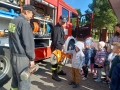 dzieci oglądają sprzęt strażacki przy wozie strażackim
