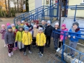 Dzieci stoją przed schodami Poczty Polskiej
