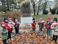 grupa dzieci z opiekunkami przy pomniku