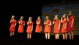występ młodych dziewcząt w czerwonych sukienkach