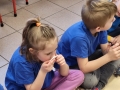 Dzieci siedzą na podłodze podczas zajęc o autyzmie.