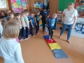 Zabawy ruchowe dzieci w sali przedszkolnej.