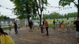 Dzieci i ich ojcowie podczas zabaw ruchowych na świeżym powietrzu.