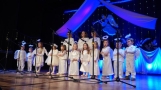 dzieci w białych strojach na scenie