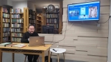 mężczyzna siedzi przy laptopie i wyświetla prezentację na rzutniku
