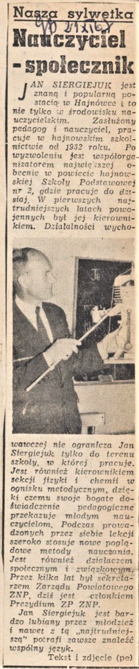 Mężczyzna stoi przy tablicy i pokazuje wskazówką urządzenie