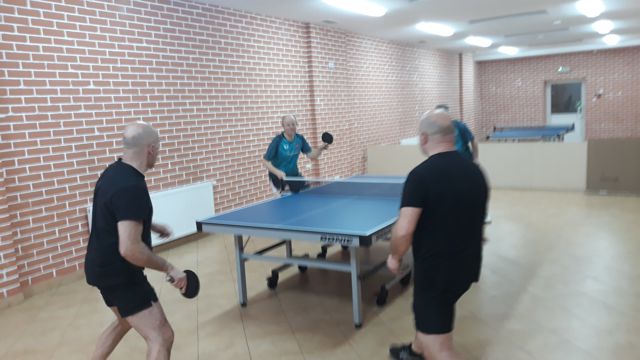 Mecz Łosice - Top Spin Siemiatycze, czterech mężczyzn ubranych w stroje sportowe gra w tenisa stołowego.