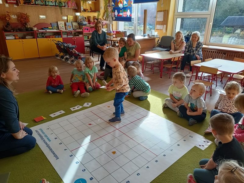 Chłopiec stoi na macie do kodowania i szuka pasujących do siebie obrazków.