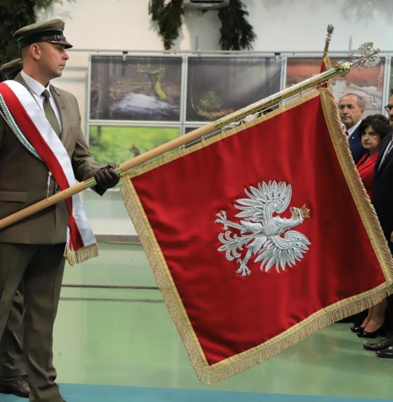 mężczyzna w mundurze trzyma sztandar