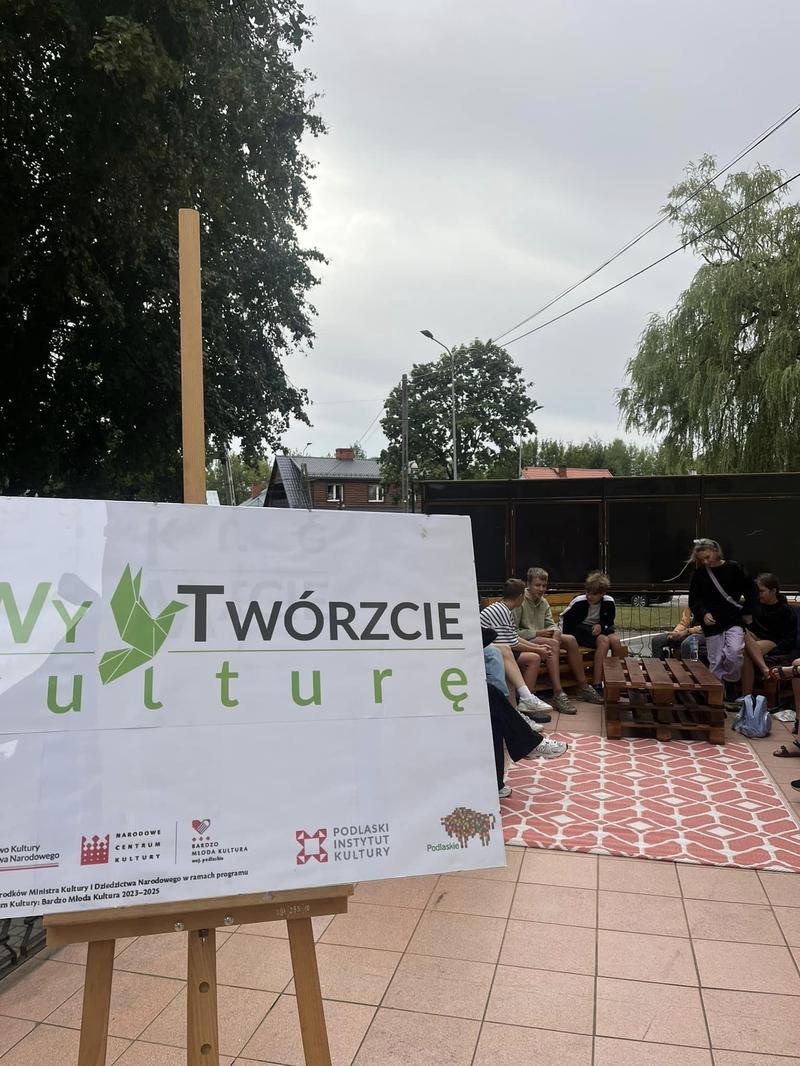 baner projektu, w tle widać siedzącą młodzież