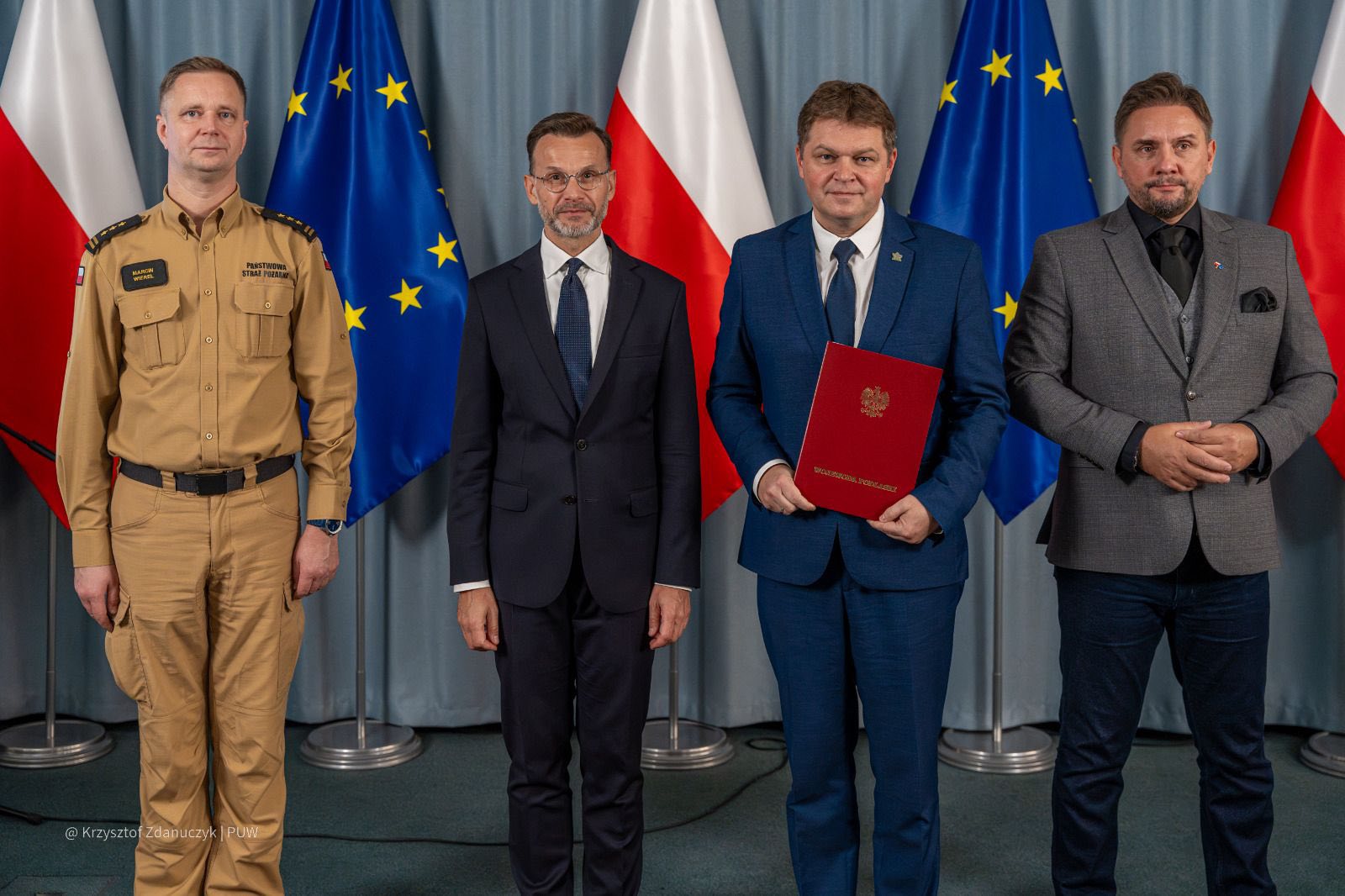 burmistrz miasta z wojewodą i wicewojewodą, przedstawicielem straży pożarnej na tle flag