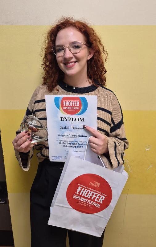 kobieta ze statuetką i dyplomem