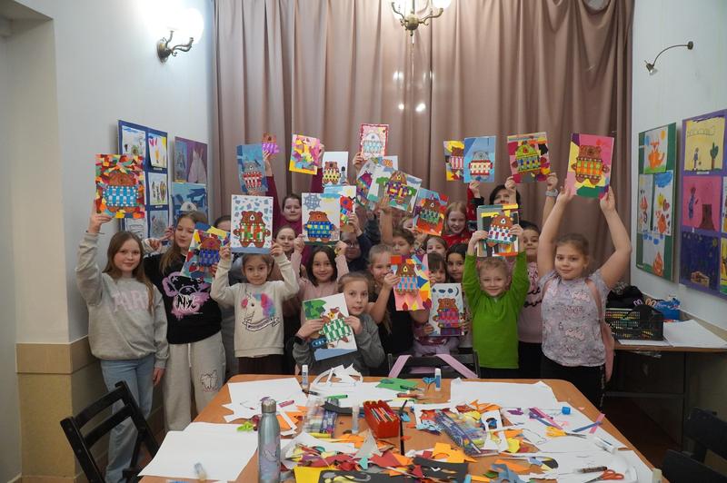 grupa dzieci prezentuje swoje prace plastyczne