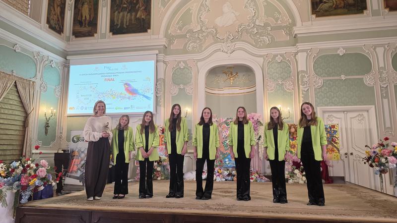 dziewczęta z instruktorą, kt&oacute;ra trzyma statuetkę pozują do zdjęcia