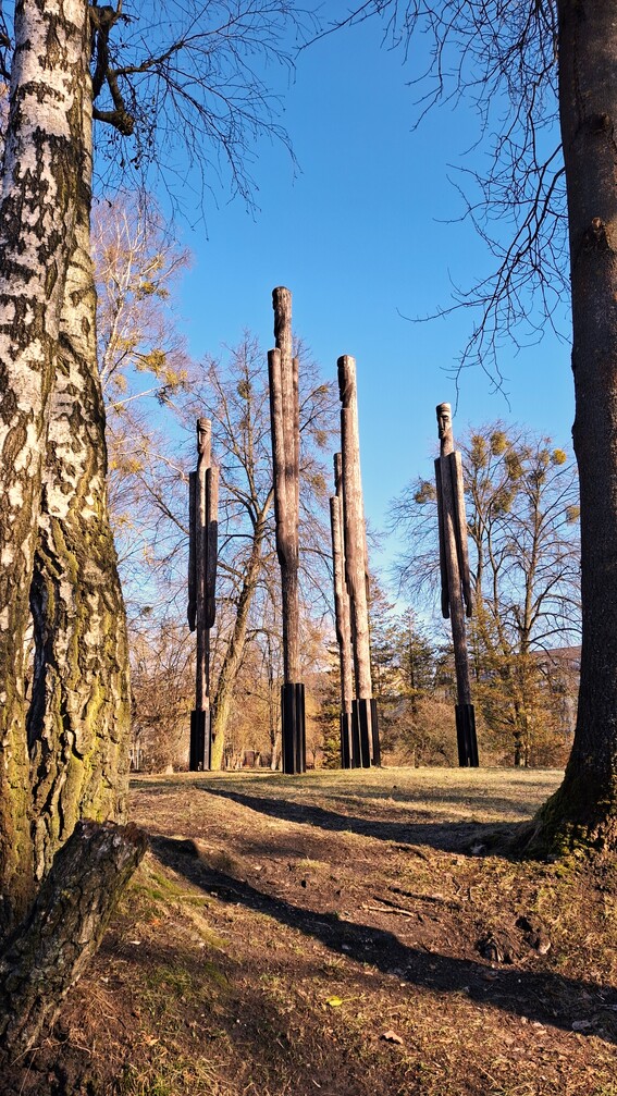 pięć wyskoich, smukłych figur imitujących postaci ludzi