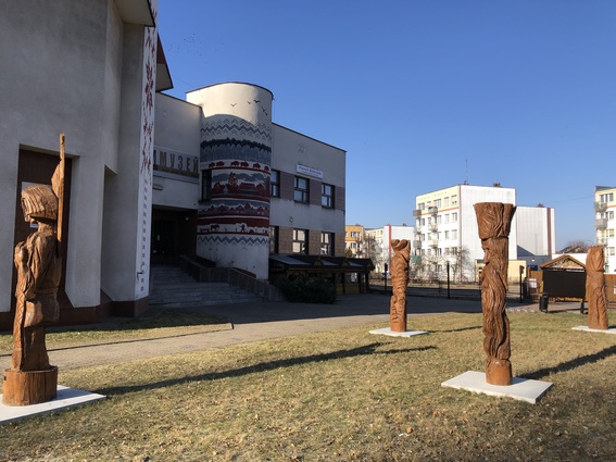 budynek muzeum, na jego frointowych ścianach murale przedstawiające wzory ludowe, w biało-czerwonych barwach