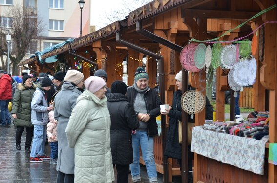 ludzie przy drewnianych domkach ustawionych na rynku