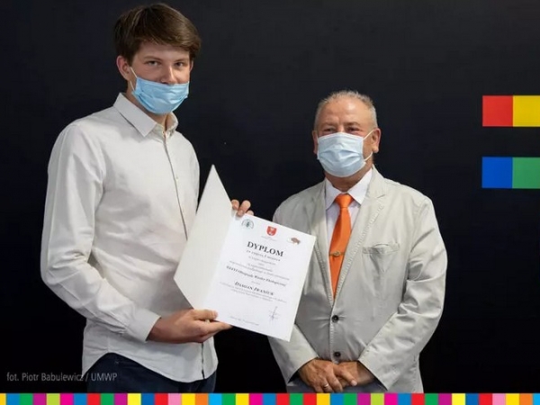 Pamiątkowe zdjęcie finalisty i wicemarszałka województwa. Finalista prezentuje otrzymany dyplom.