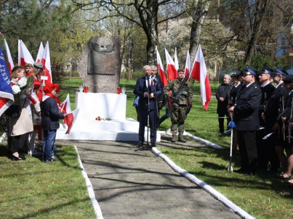 Obelisk, po obu stronach biało czerwone flagi, obok obelisku przemawia Burmistrz.