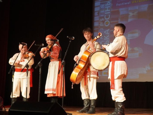 cztery osoby ubrane w ludowe stroje grają na instrumentach