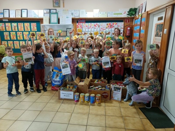 zdjęcie grupowe dzieci z dyplomami oraz z karmą dla zwierząt