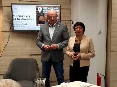 mężczyzna i kobieta stoją przed słuchaczami przy prezentacji