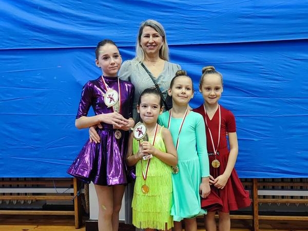 tancerki z medalami pucharami i trenerką