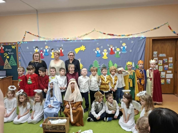  jasełka bożonarodzeniowe w wykonaniu grupy piątej na tle bożonarodzeniowej dekoracji