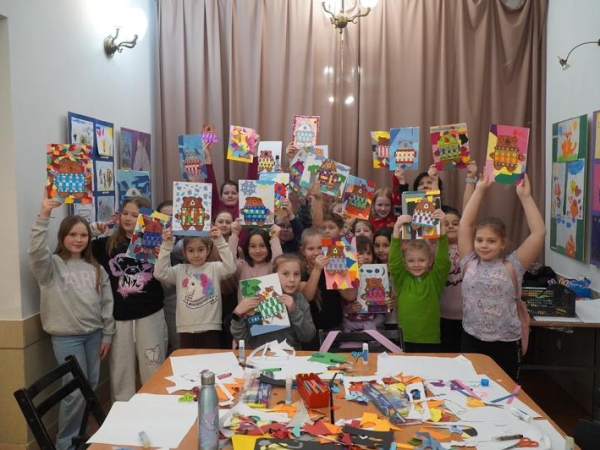 grupa dzieci prezentuje swoje prace plastyczne
