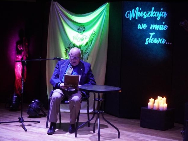 mężczyzna czyta na scenie poezję