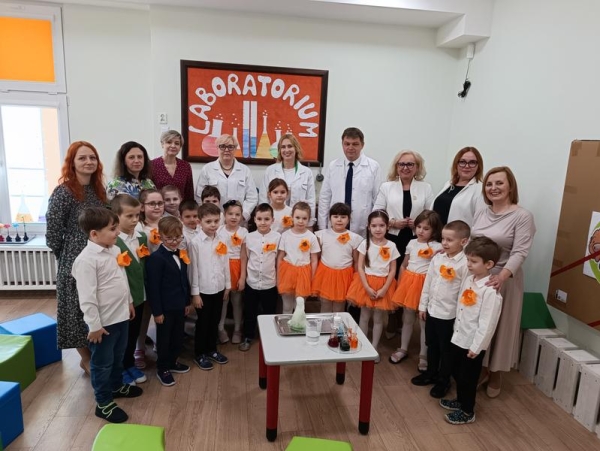 Wspólne zdjęcie uczestników wydarzenia w sali laboratoryjnej