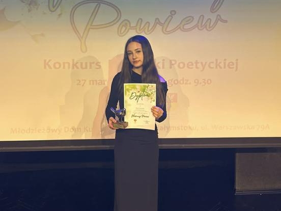 solistka z dyplomem pozuje do zdjęcia na scenie