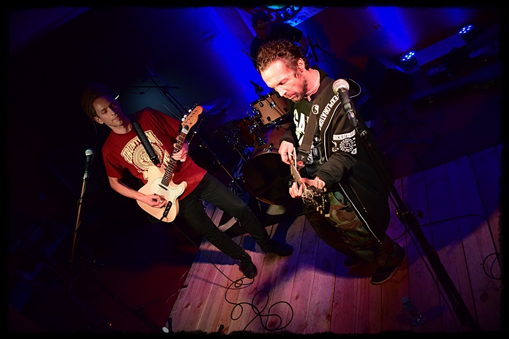 dwaj mężczyźni grający na gitarach elektrycznych